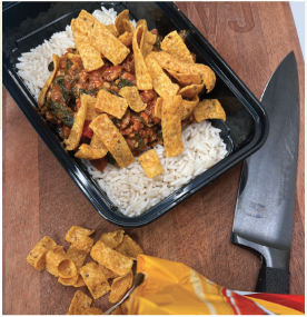 Taco meal prep bowl with rice, seasoned meat, and corn chips